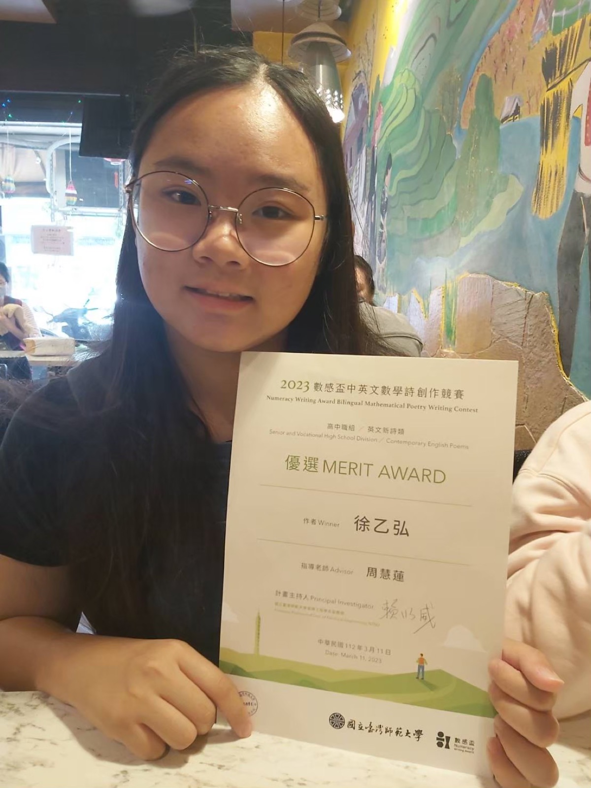 Holding the Numeracy Writing Award Merit Award certificate