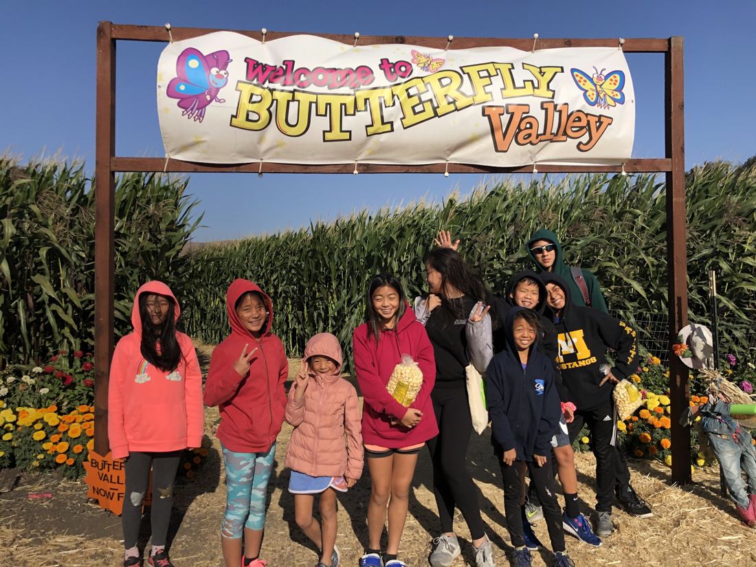 Group at the pumpkin patch's Butterfly Valley sign